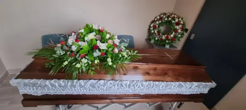 Изкуствени цветя аранжирани върху ковчег