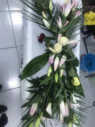 Естествени цветя аранжирани върху ковчег