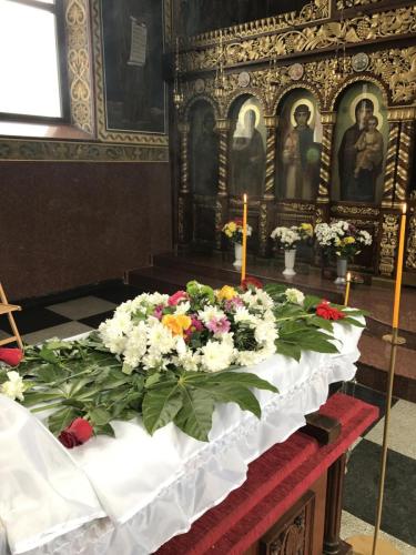 Естествени цветя аранжирани върху ковчег