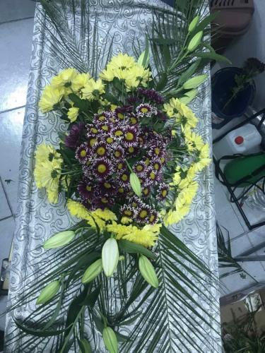 Естествени цветя аранжирани върху ковчег