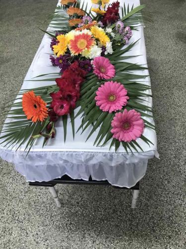 Естествени цветя аранжирани върху ковчег